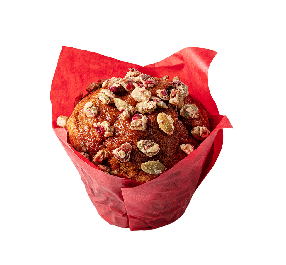 A muffin topped with chopped nuts inside a red paper lining.