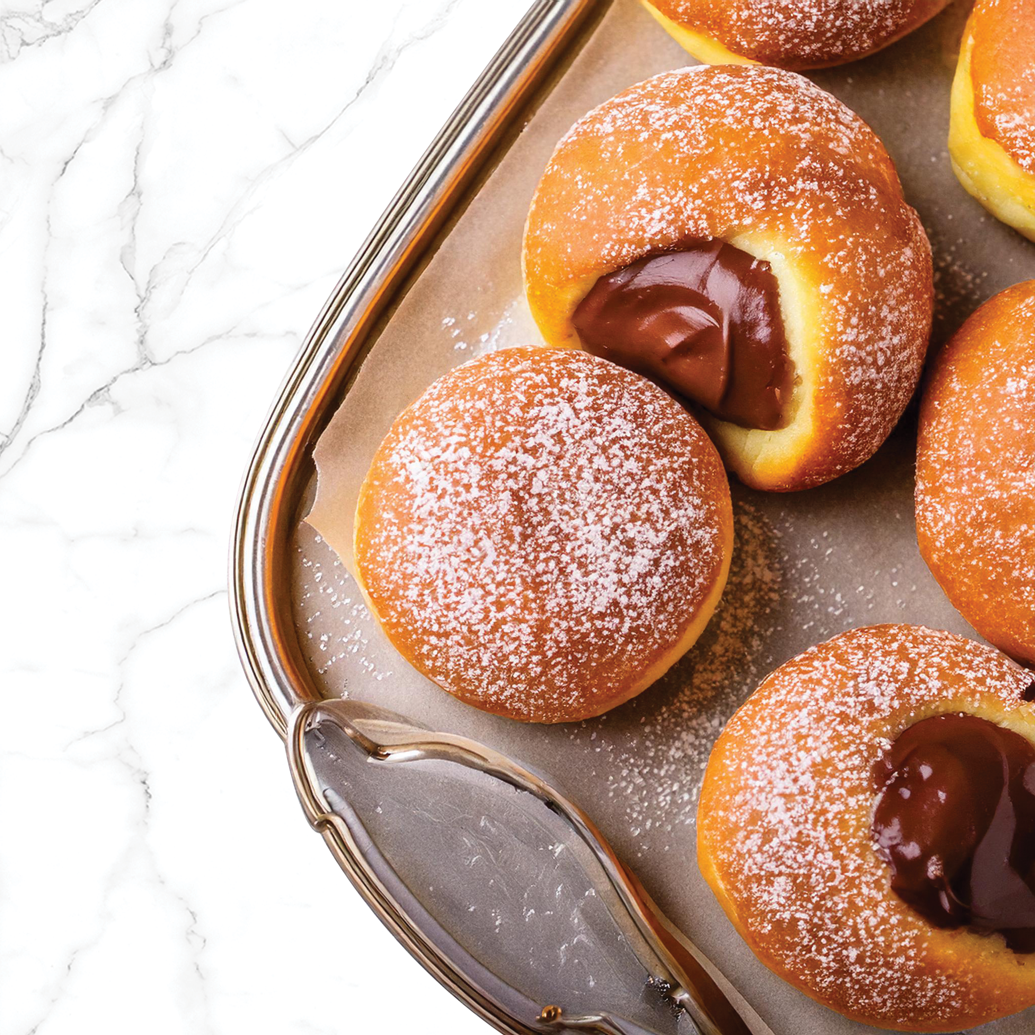 Close-up of chocolate-filled donut holes on a baking sheet