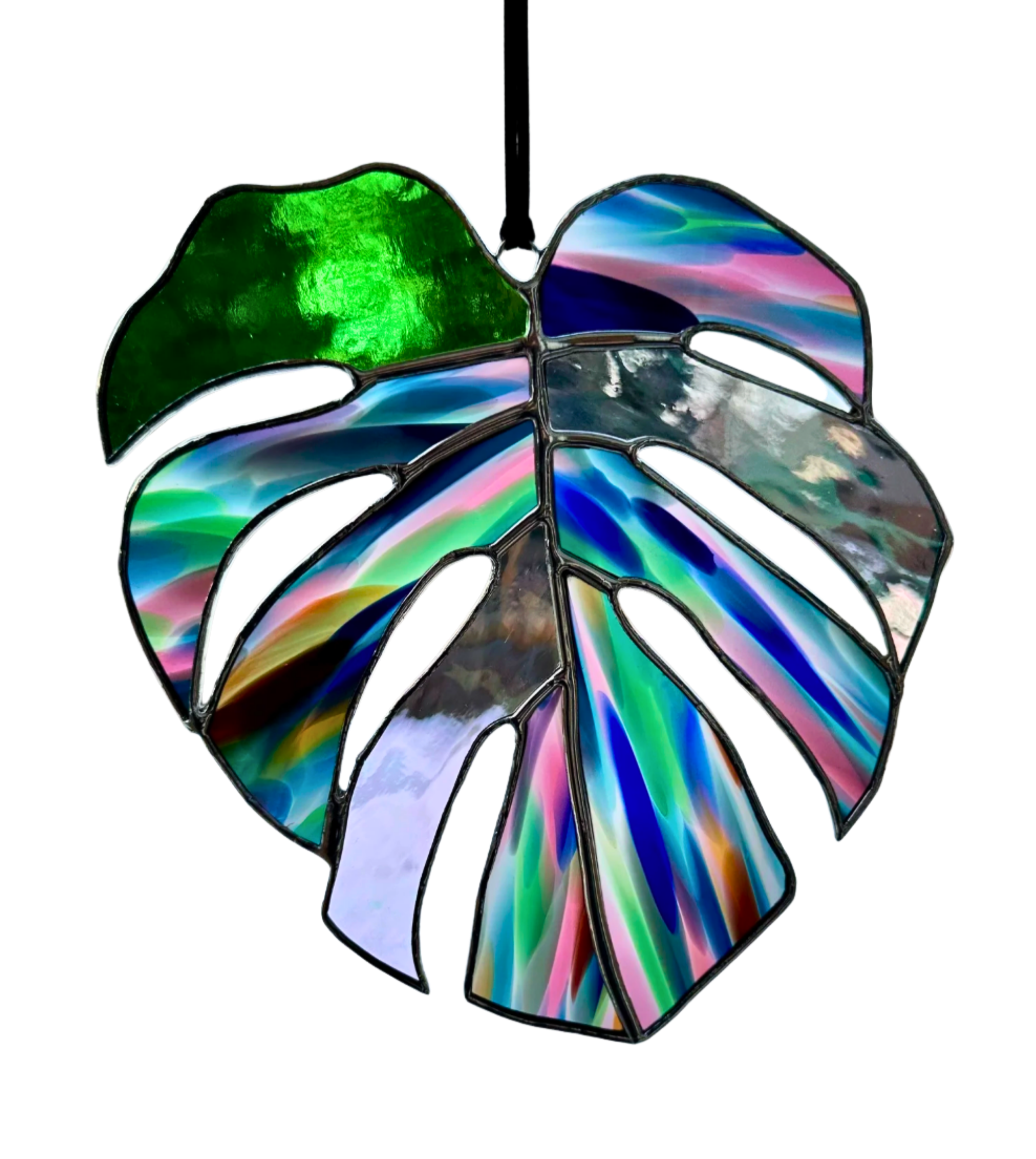 Colorful stained glass window in the shape of a tropical leaf with various mirrored and translucent sections.