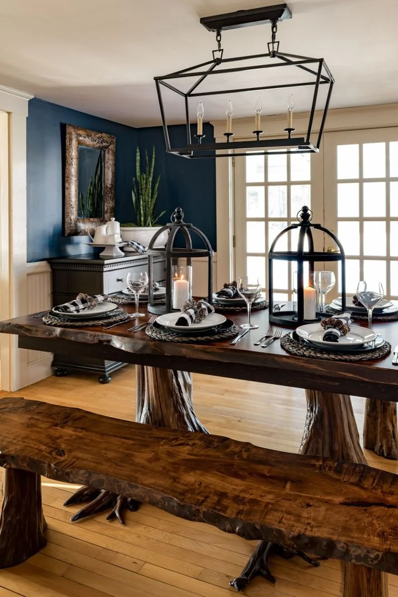 Live edge rectangular dining table with black metal open lantern light fixture above