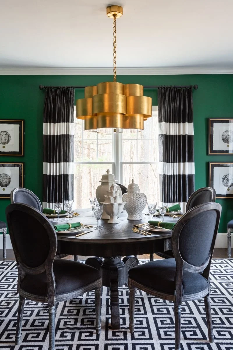 Green and black dining room with gold chandelier close up