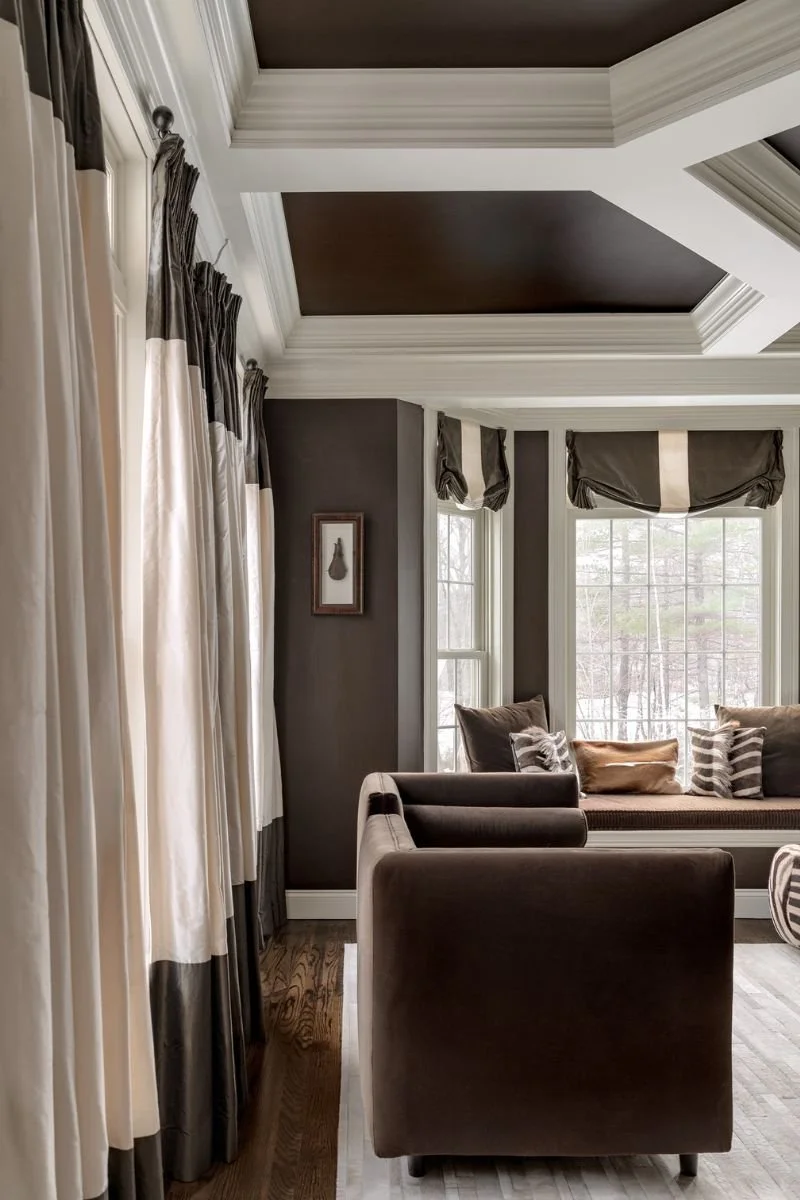 Side view of sitting room in rich browns and creams with geometric coffered ceiling