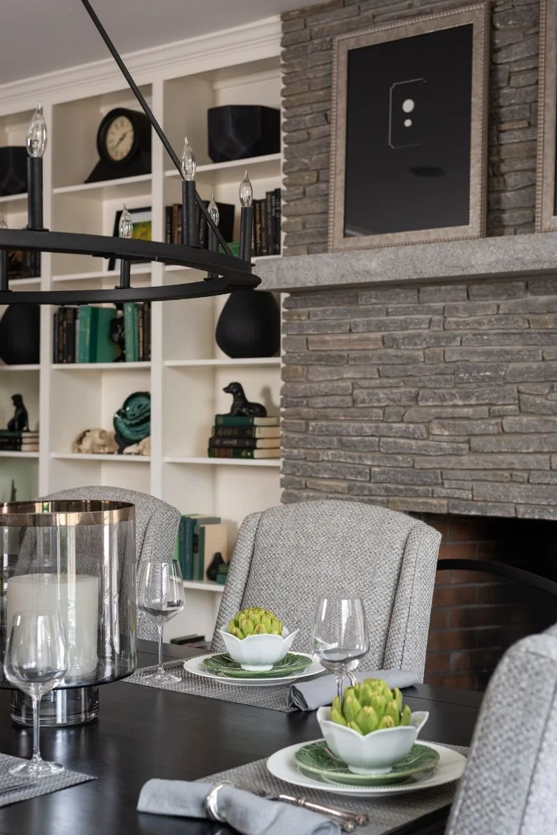 Round dining table in front of natural stone fireplace