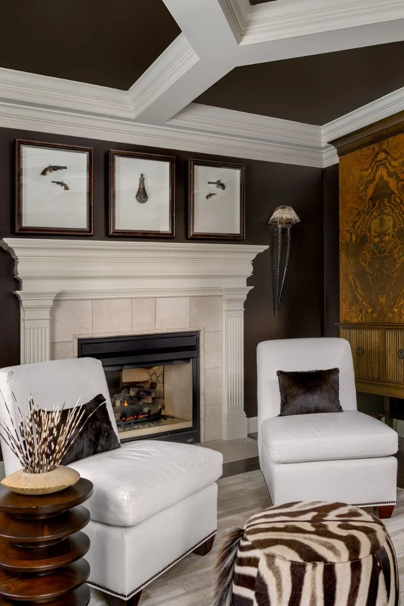 Classic millwork surrounds this elegant fireplace framed by two white slipper chairs