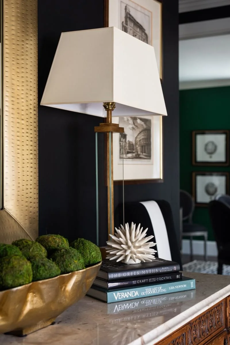Davenport with slim, elegant lighting, a stack of books and other decor