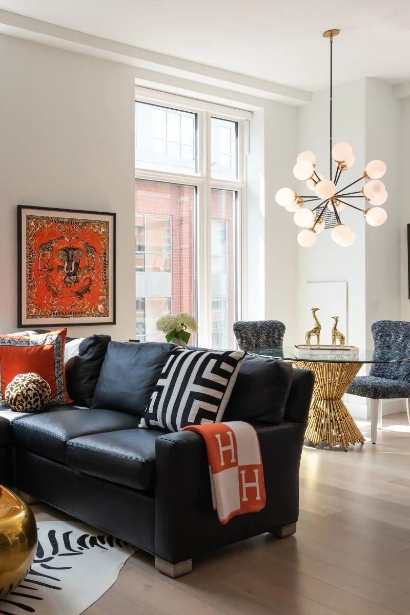 Another view of the living room with black sofa and vibrant red framed print