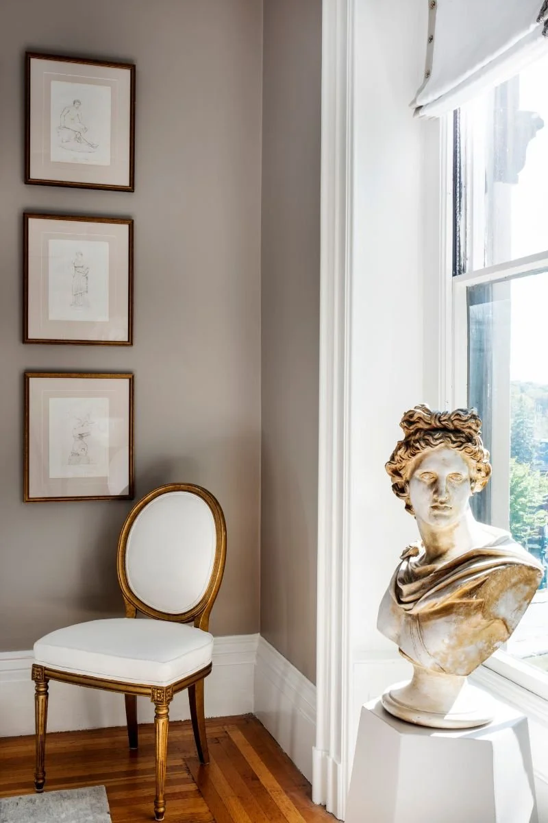 Classic medallion chair in cream and Romanesque bust in a sunny corner