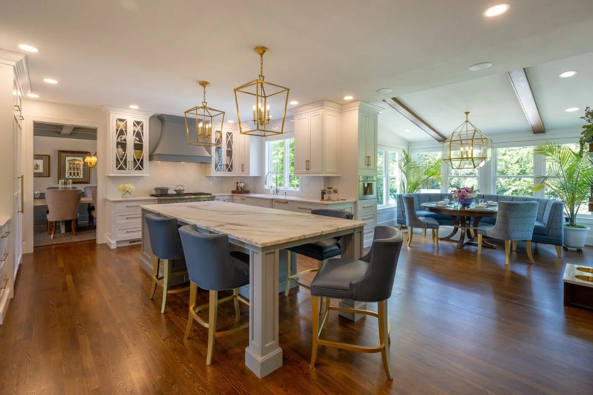 Large, luxurious, custom kitchen with breakfast nook with exposed beams and open lantern style faux candle pendants