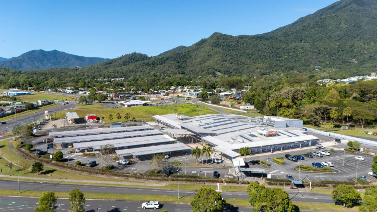 Aerial view of commercial precinct in Cairns with lush rainforest background