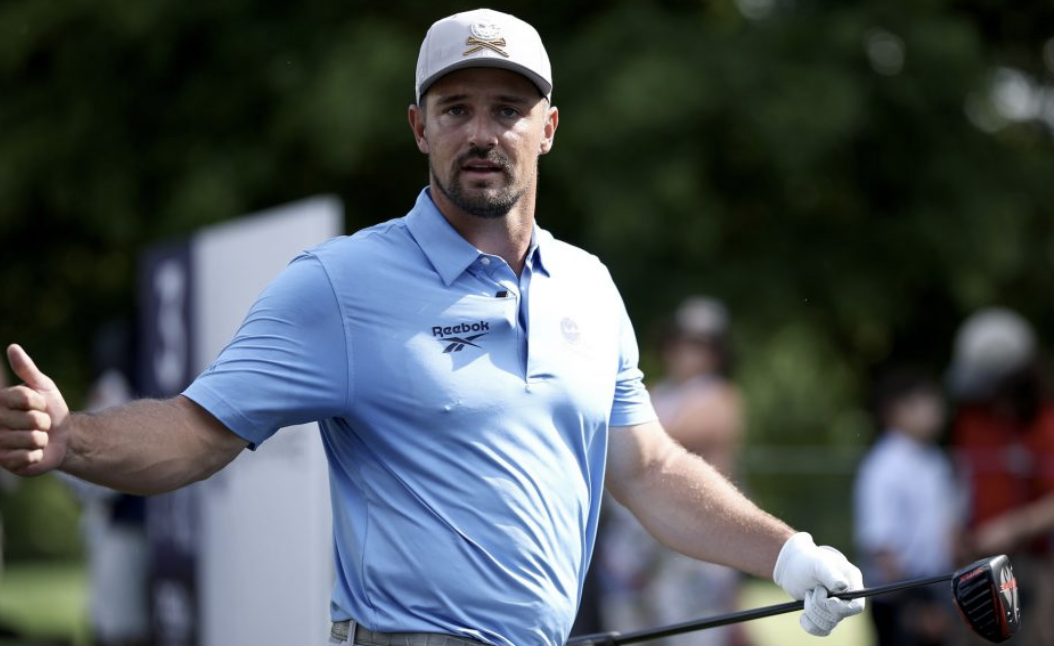 Golfer showing positive body language, giving a “thumbs up" after their shot.