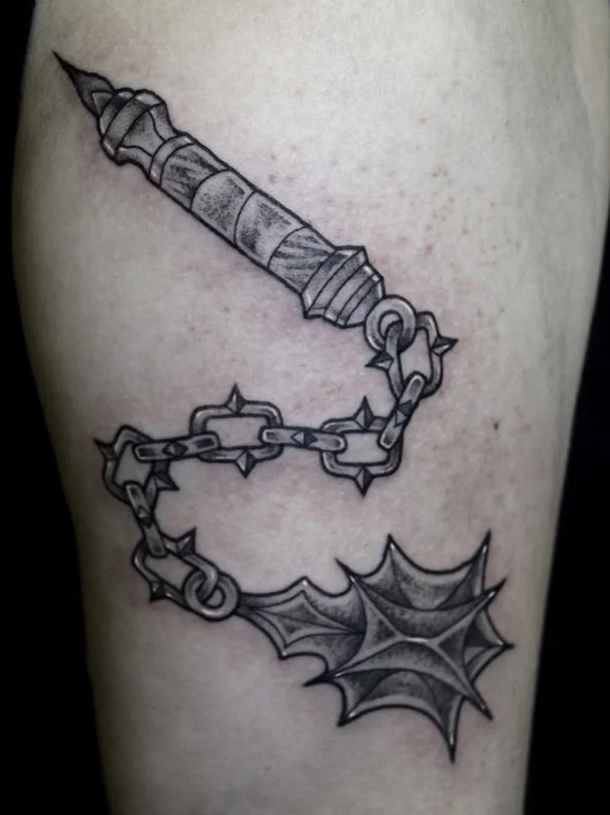 Tattoo of a medieval flail on the upper arm.