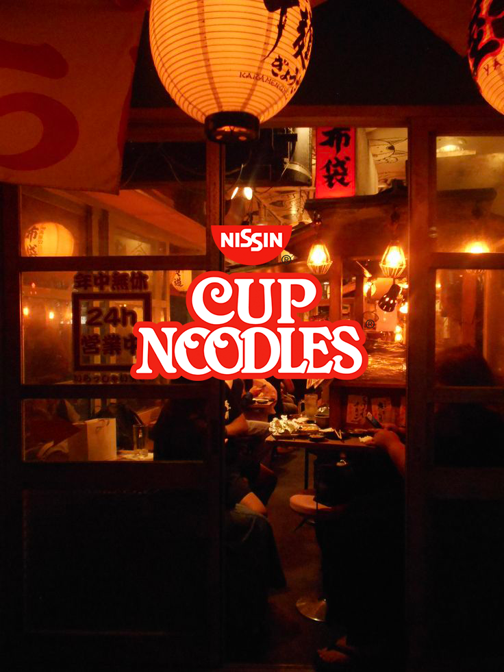 The entrance of a Japanese restaurant featuring warm lighting, hanging paper lanterns with Japanese characters, and a sign for Nissin Cup Noodles.