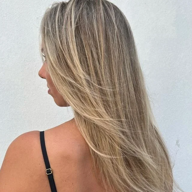 Soft caramel blonde balayage on long wavy hair in Pimpama and Robina – low-tox, healthy hair colour specialist Gold Coast