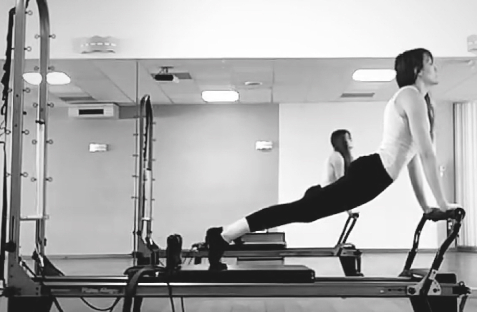 Femme faisant de l'exercice sur un tapis de Pilates dans une salle de sport à Valence dans la Drôme.