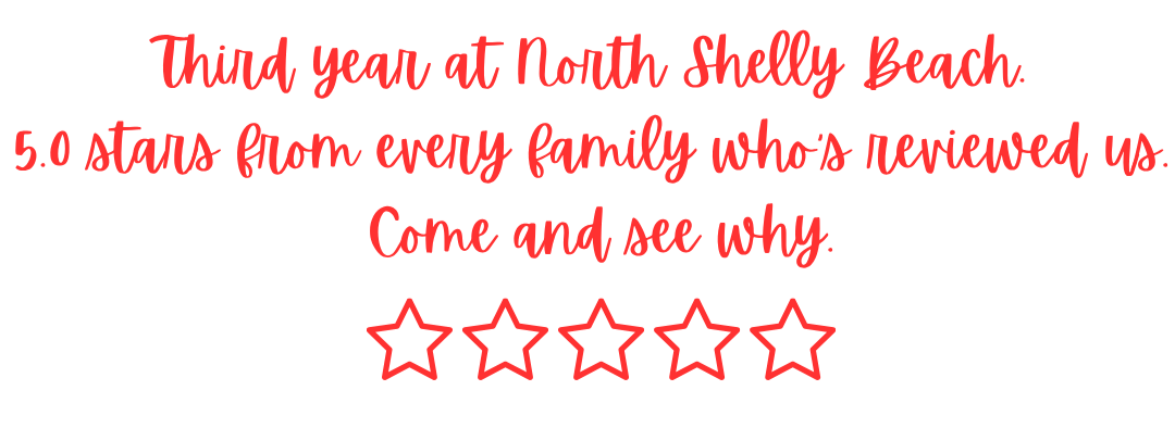 Text sign promoting North Shelly Beach with five red stars and the message: 'Third year at North Shelly Beach. 5.0 stars from every family who reviewed us. Come and see why.'
