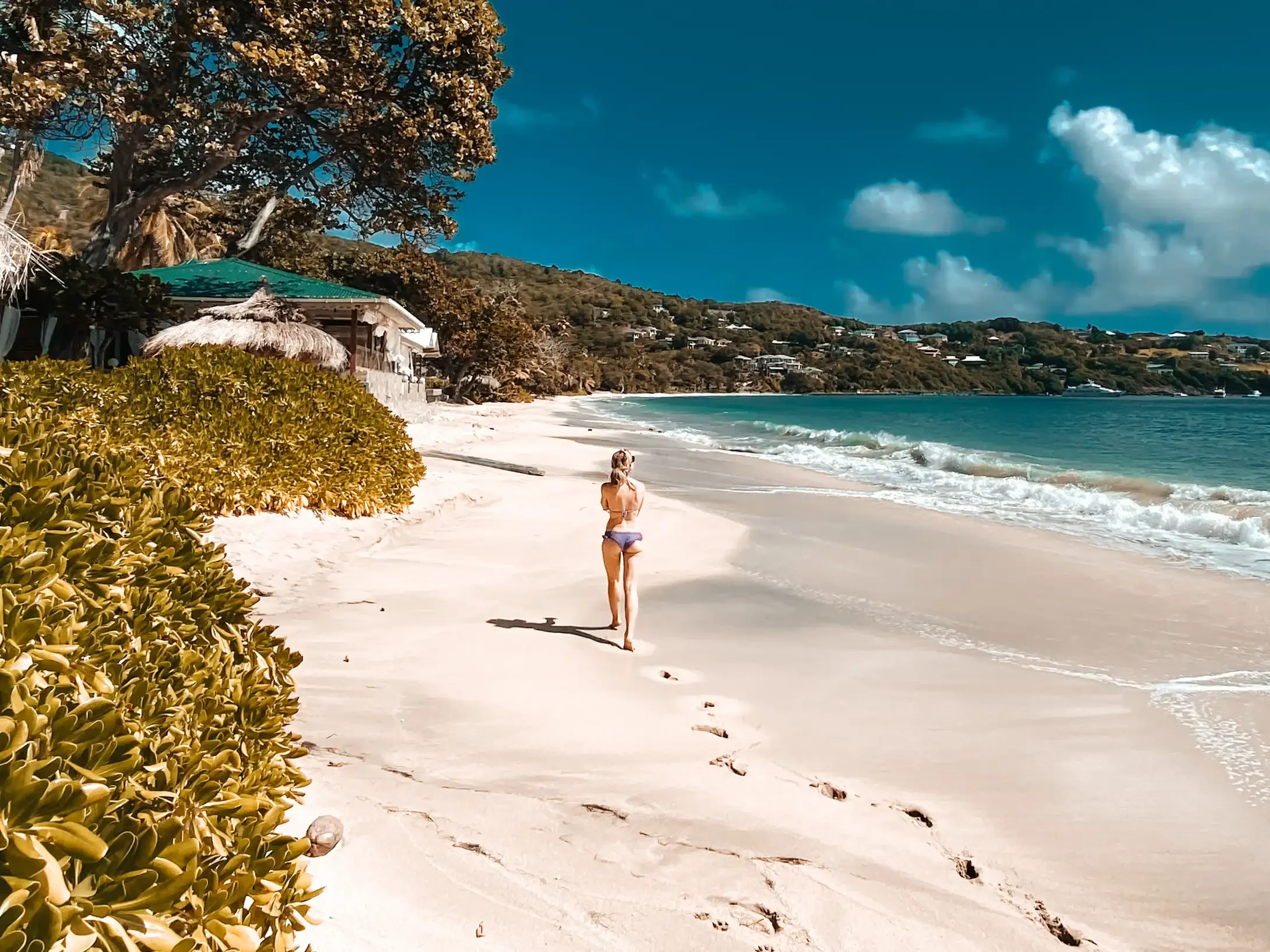 Girl walking on a beach with footprints
