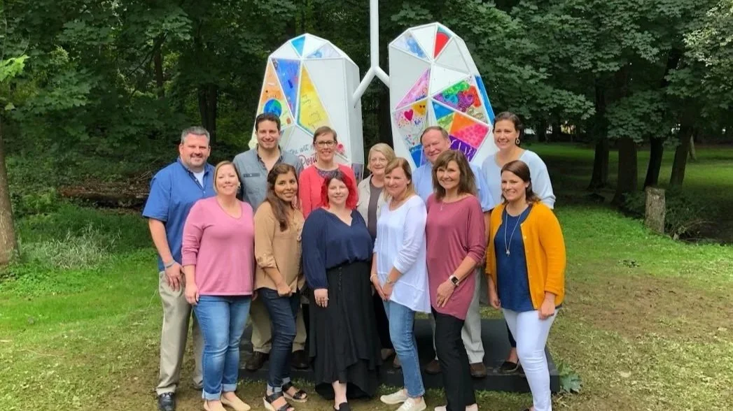 People standing infront of a large wooden lung