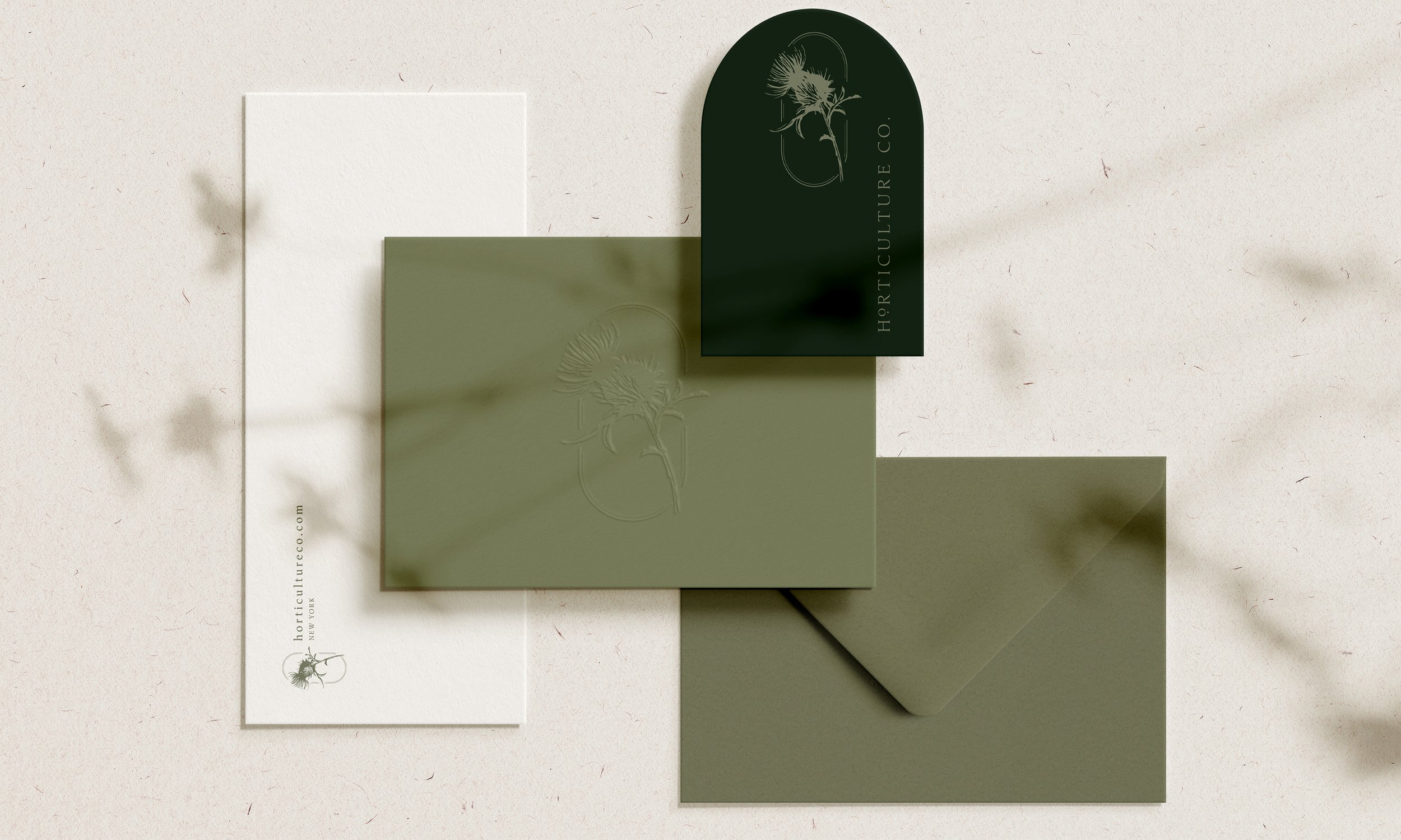 Flat lay of business cards and envelopes with green, white, and olive color schemes, featuring a botanical logo and text for Horticulture Co.