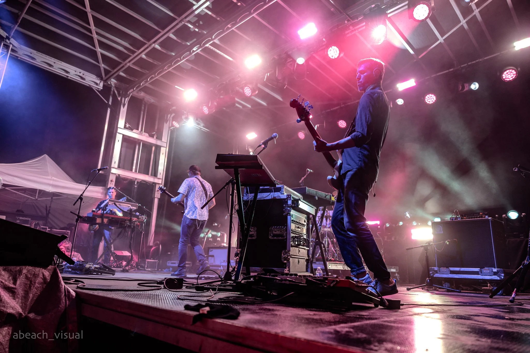Lotus performing live on stage with musicians playing instruments and colorful stage lighting.