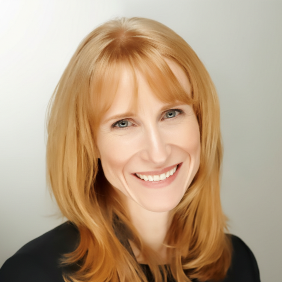 Woman with long red hair smiling at the camera, wearing a black top against a light background.