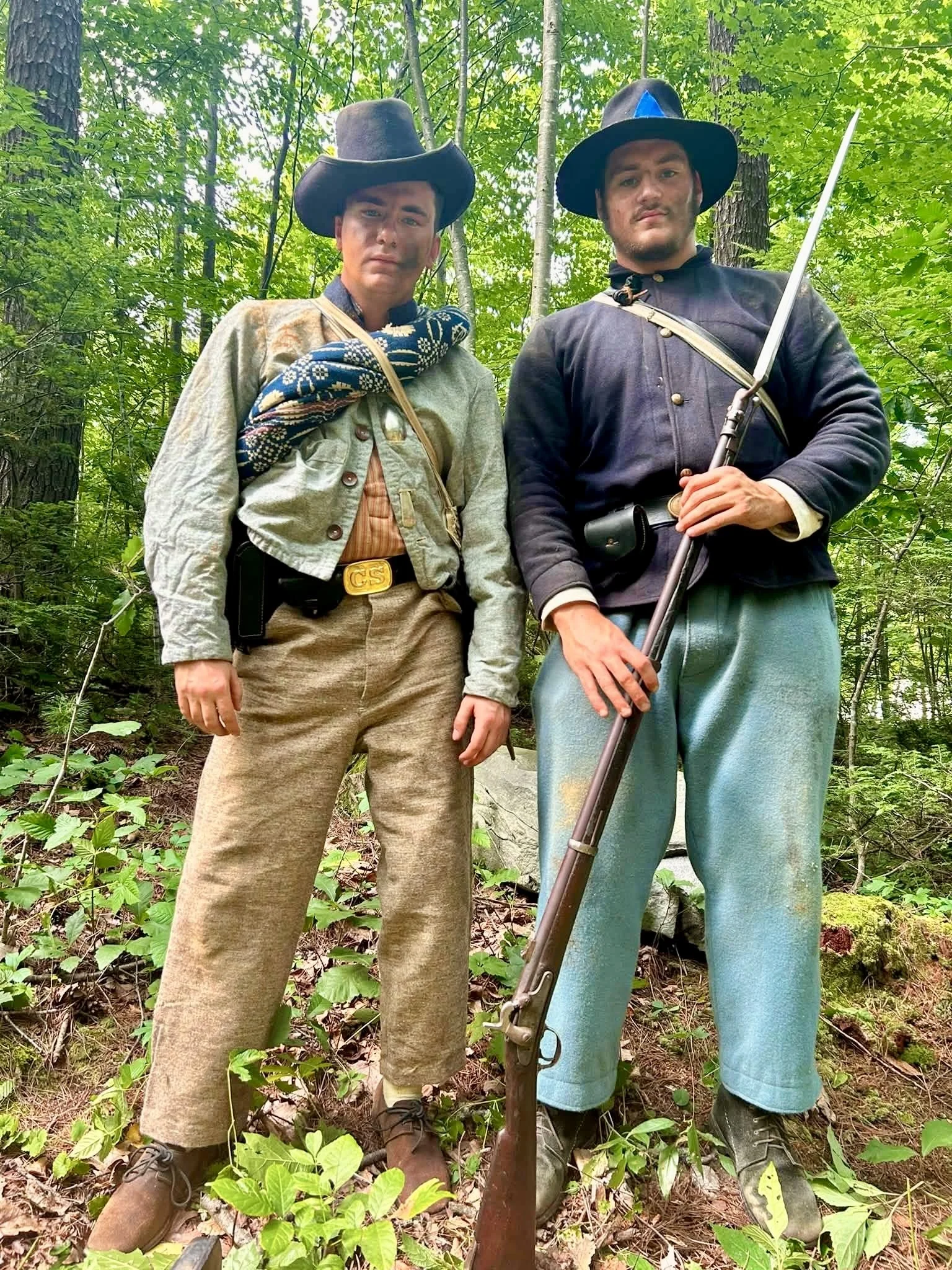 A Confederate soldier and a Union soldier stand side by side 