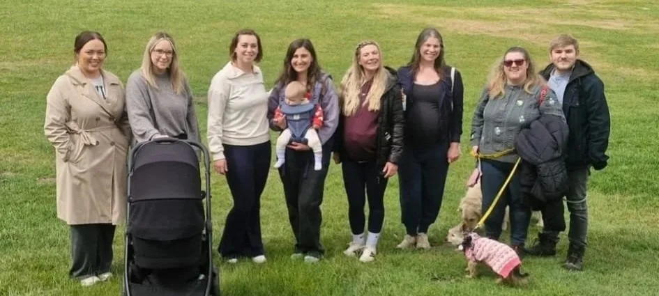 Group of friends standing outdoors with a dog.