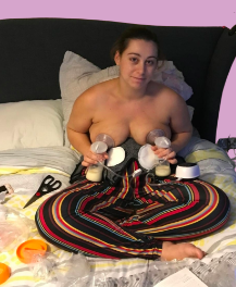 Paige breastfeeding her baby while sitting in bed.