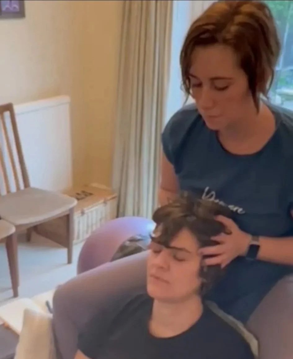 Doula providing gentle head massage during a relaxation session.