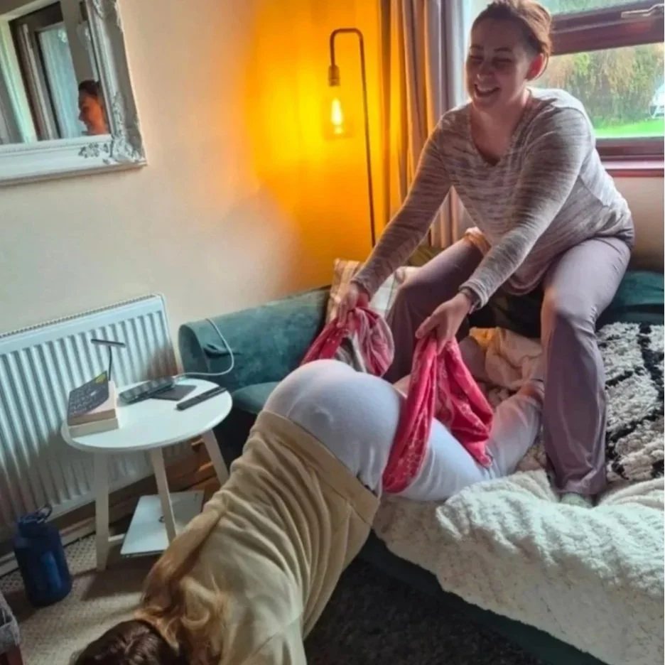 Doula supporting a woman leaning forward during labour at home.
