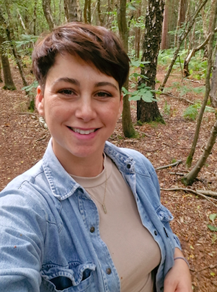 Paige Briggs of Paige’s Doula Service standing outdoors in woodland