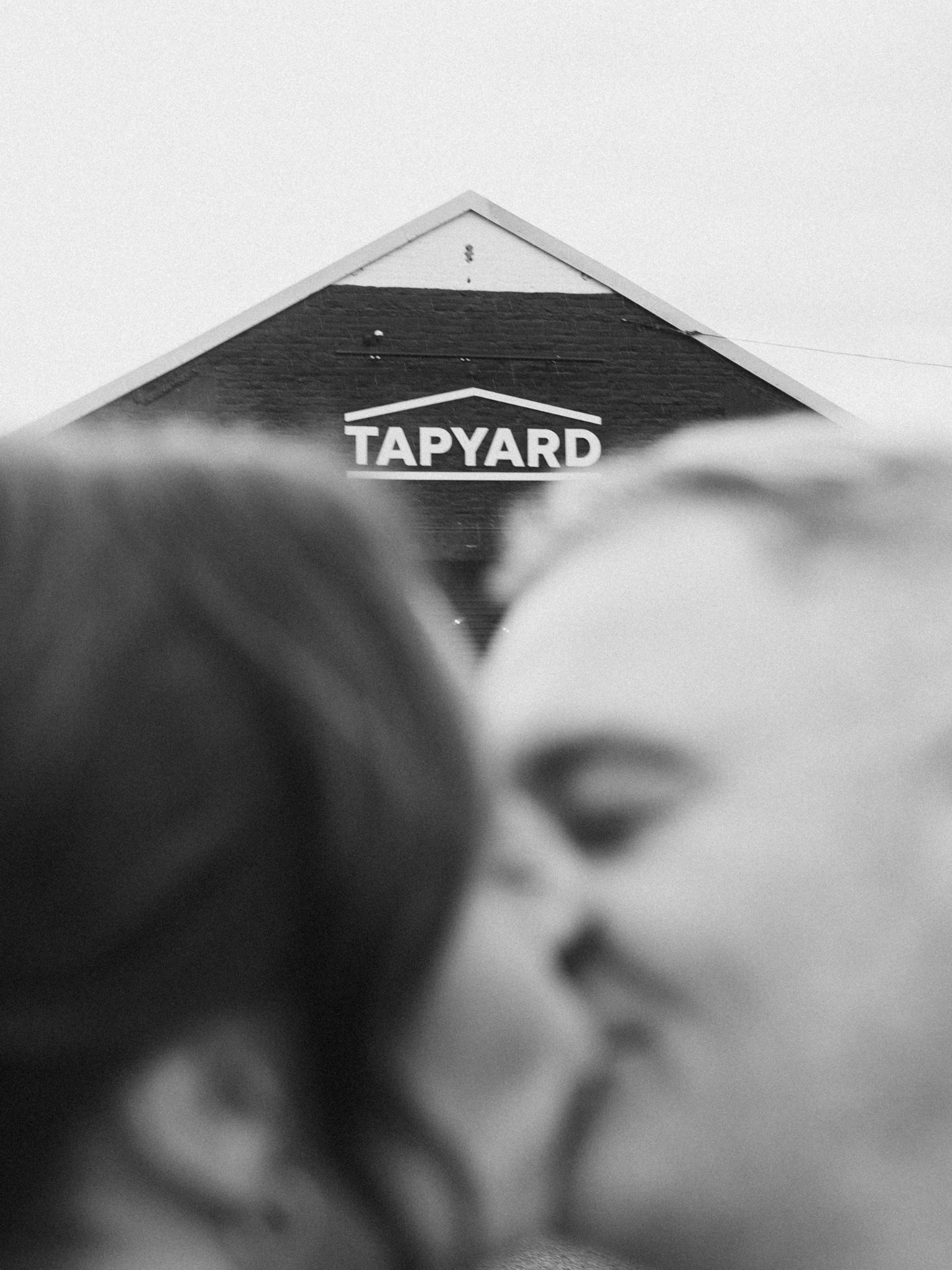 Black and white photo of a house roof with a sign that reads 'TAPYARD'.