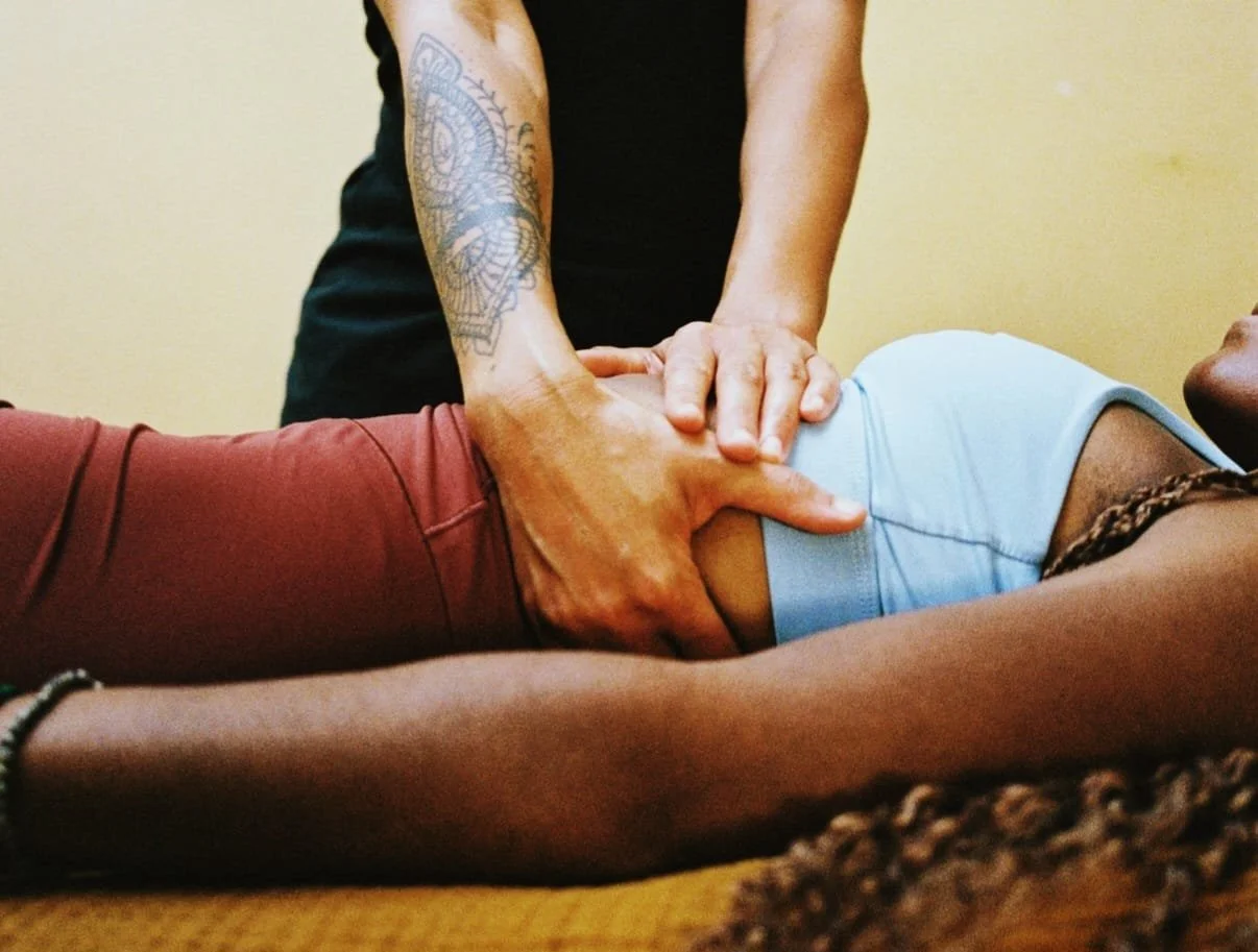 A patient lies on a treatment table while an osteopath performs a rib mobilisation technique.