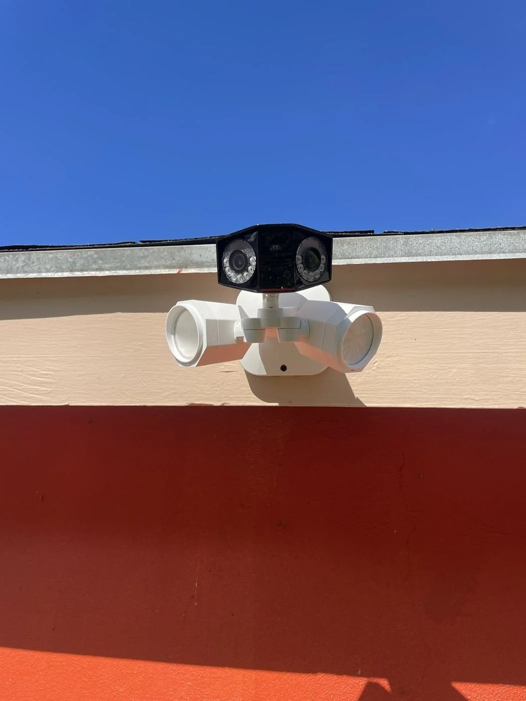 Dual-lens security camera with motion floodlights, commercial eave mount