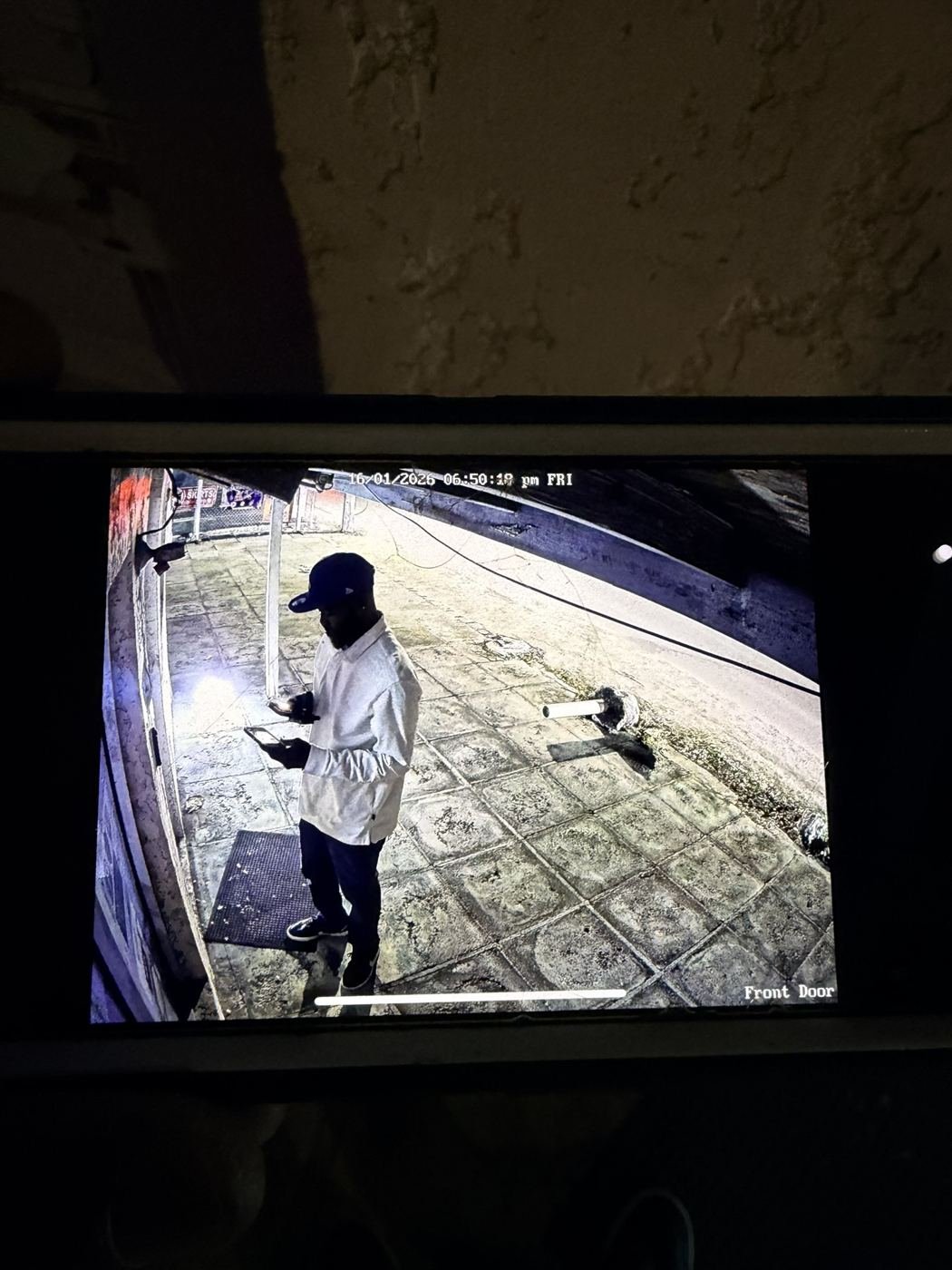 Clear night-time CCTV footage at a storefront entrance