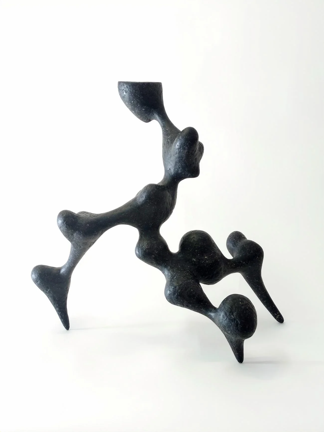 Bicho II black recycled paper sculpture by Justino Del Casar, angled view showing its organic, jointed limbs