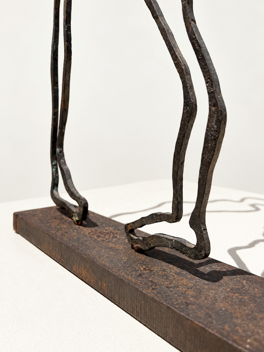 Detail of the feet of Contact by Robert Pous, bronze figures anchored on a textured metal base