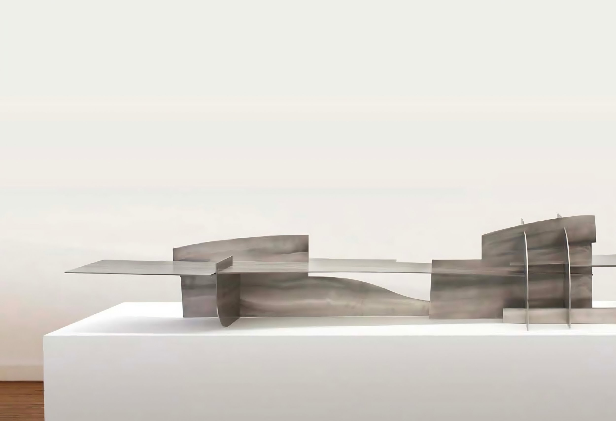 Horizontal brushed-steel sculpture with interlocking geometric planes by Pablo Leonardo.