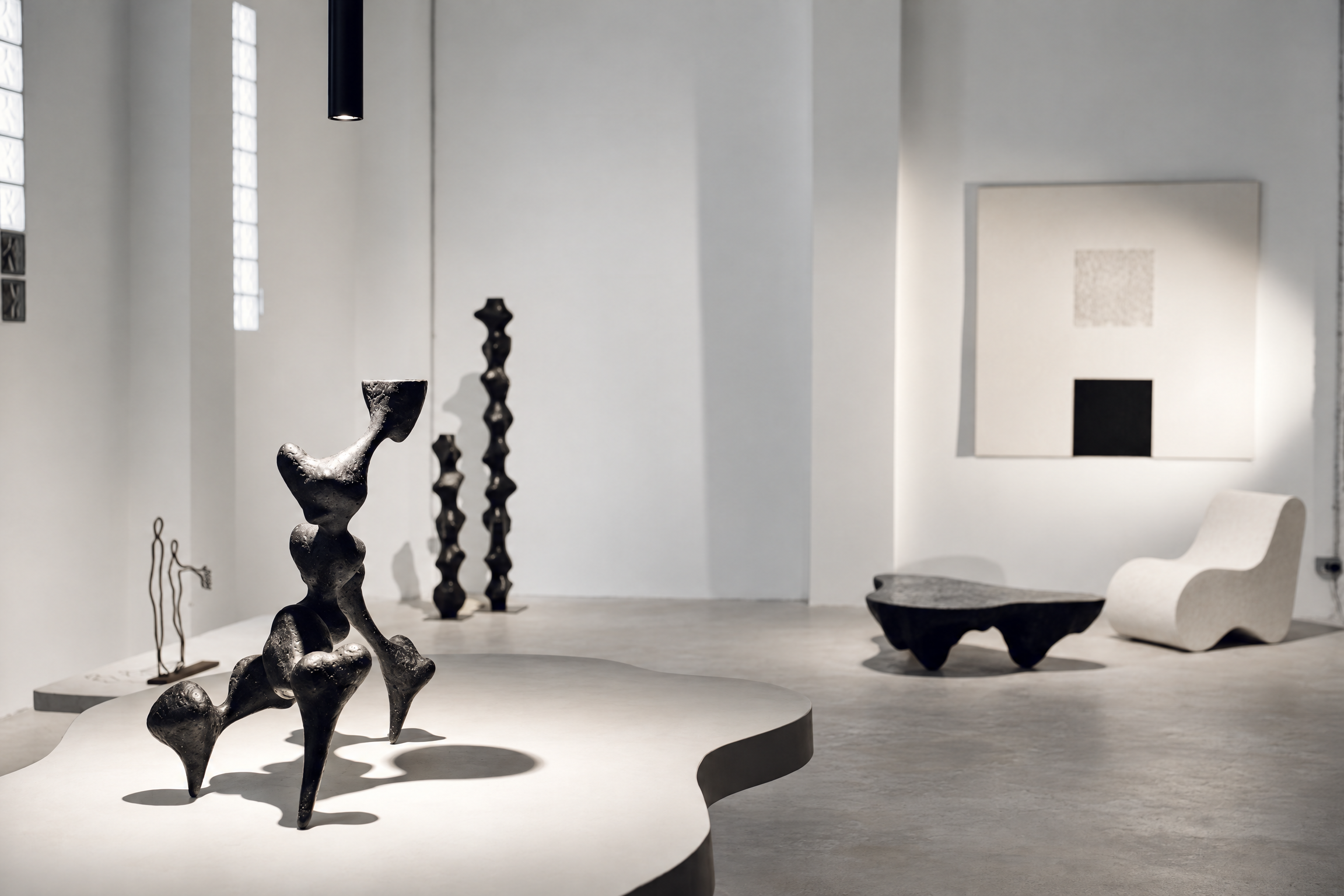Blanconegro gallery: paper organic sculpture on curved plinth, black totems, black table, white chair and black-square canvas.