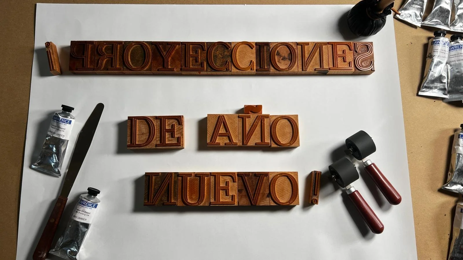 Letterpress printing workshop setup with wood type and cotton paper, ready for participants.