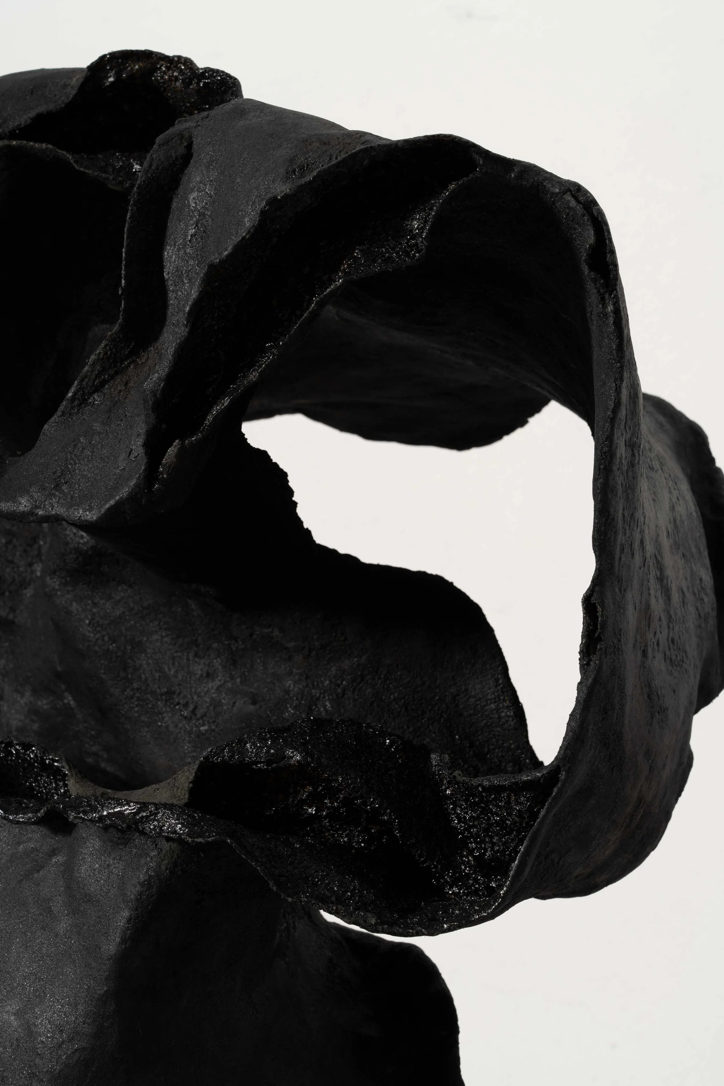 Close-up of cracked lacquer surface revealing earthy inner structure in sculpture