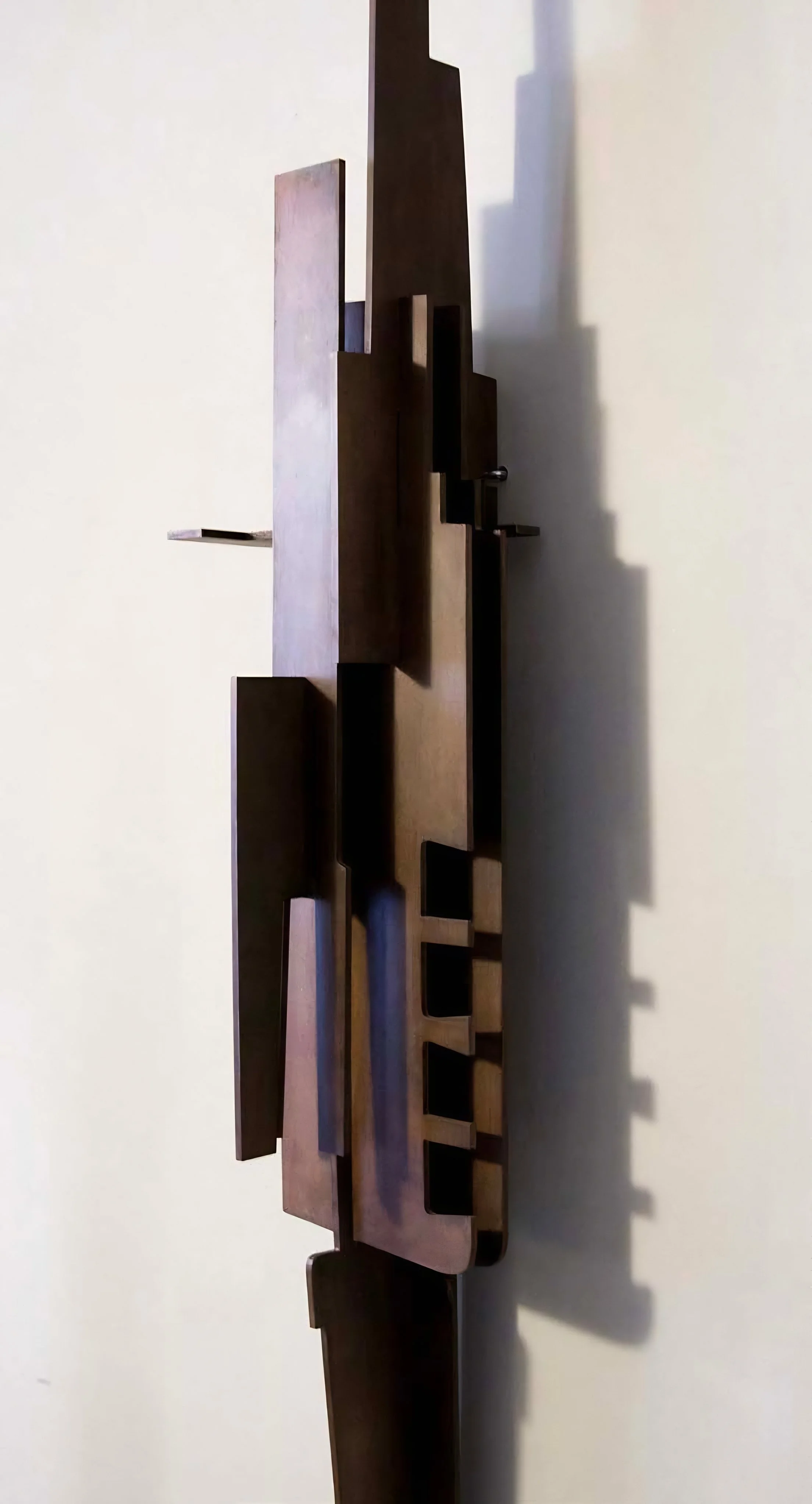 Tall corten steel sculpture with geometric interlocking planes by Pablo Leonardo.