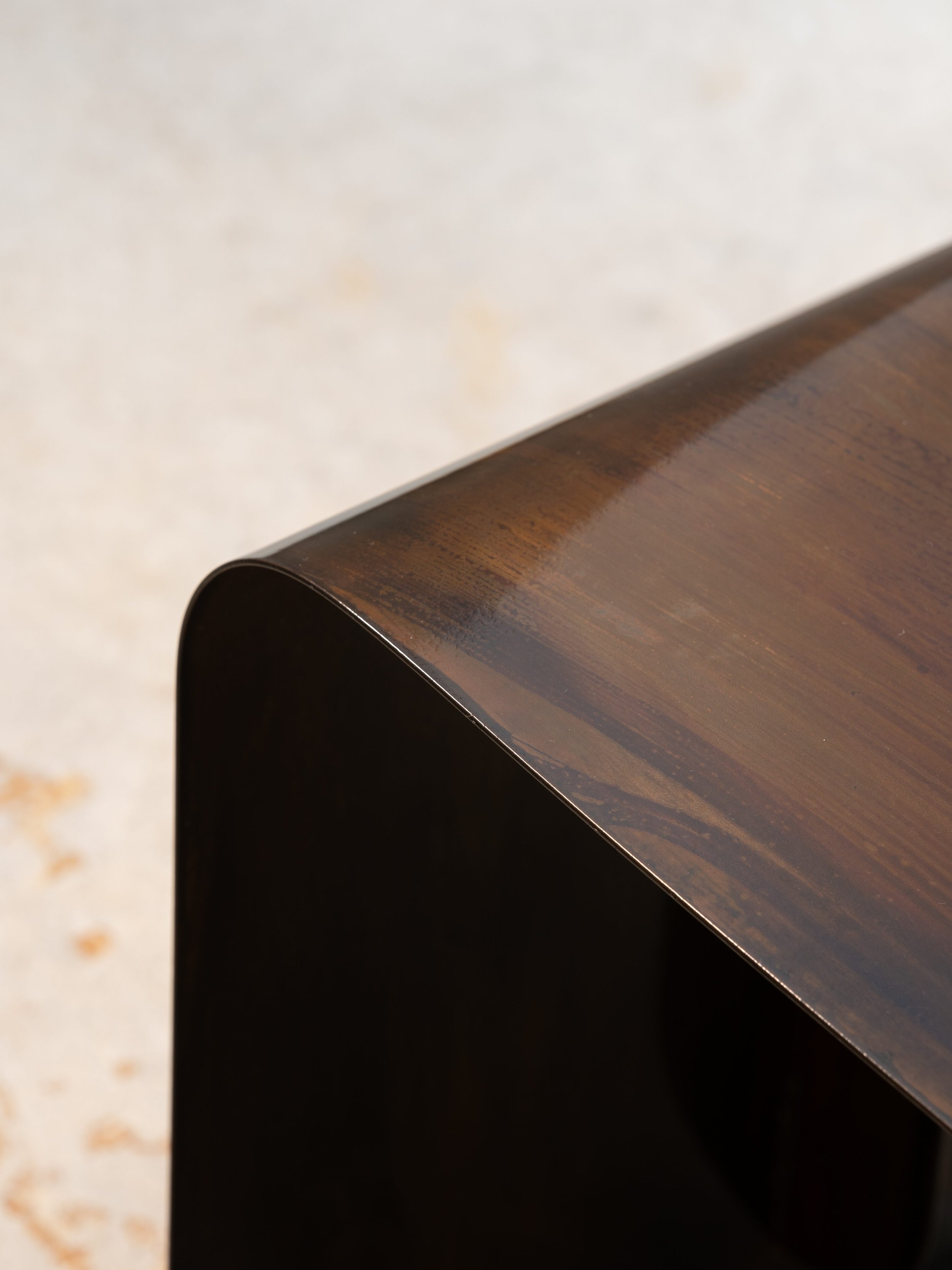 Art-design bench with monolithic form and patinated surface, exclusive to EAST WEST SPACE