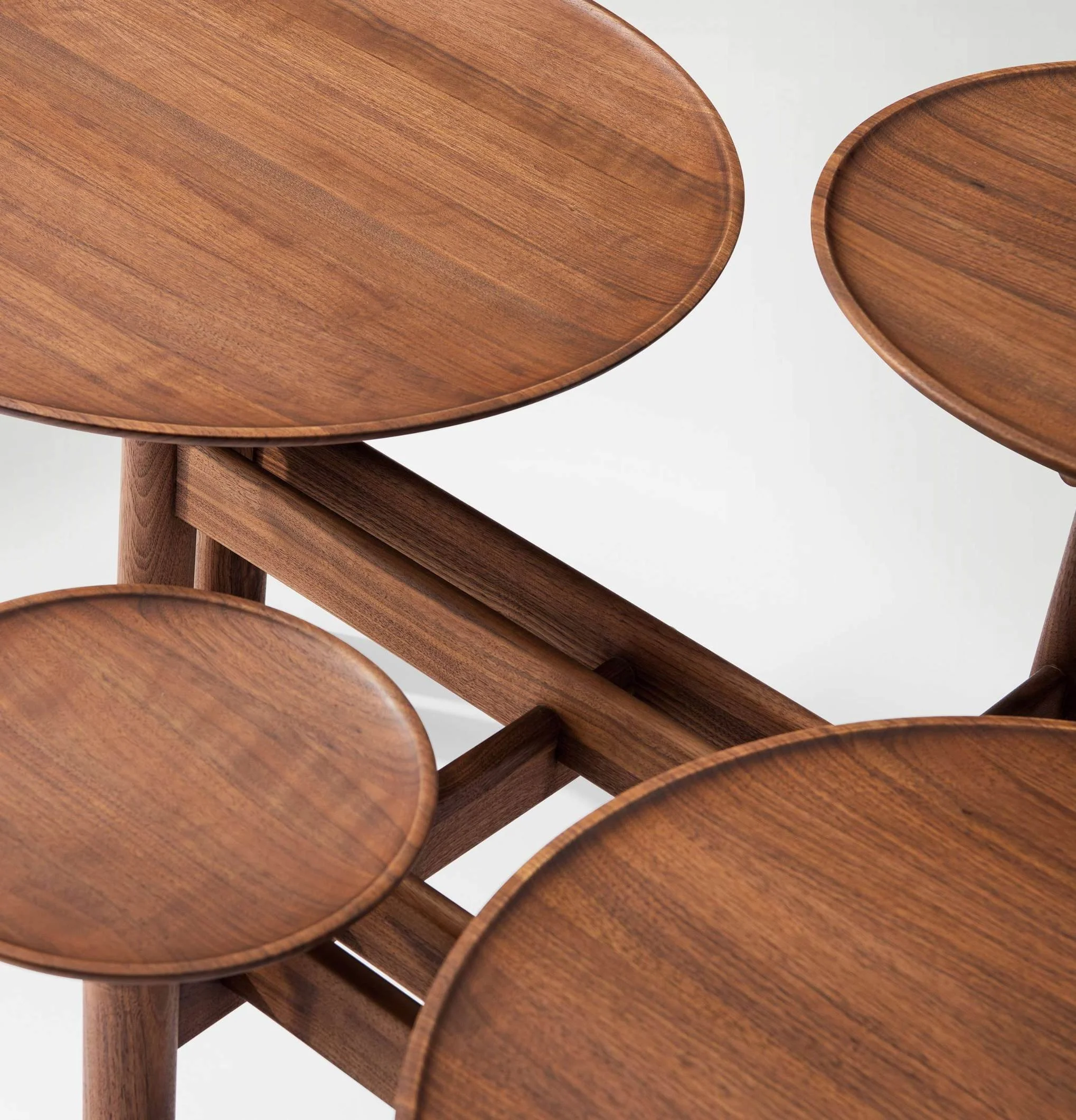 Luxury wooden table with interconnected circular tops resembling pond ripples.