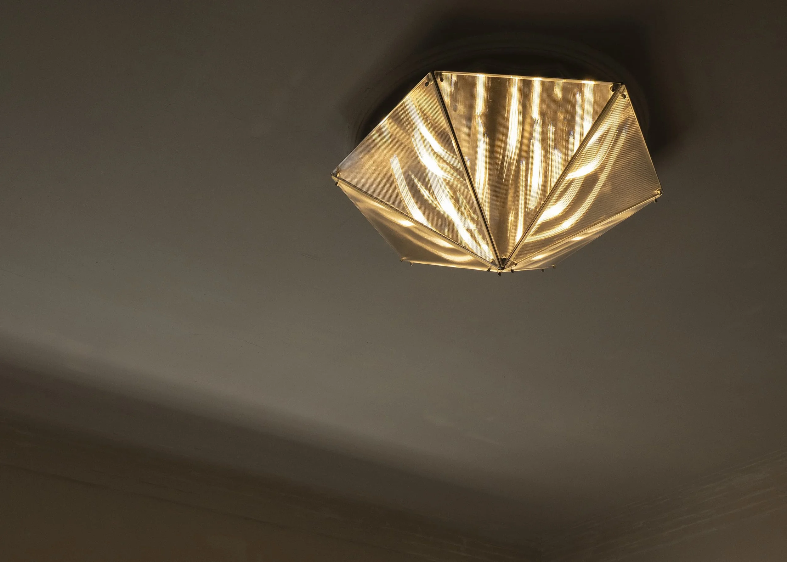 Sculptural lighting object with prismatic translucent surfaces by Sing Chan.