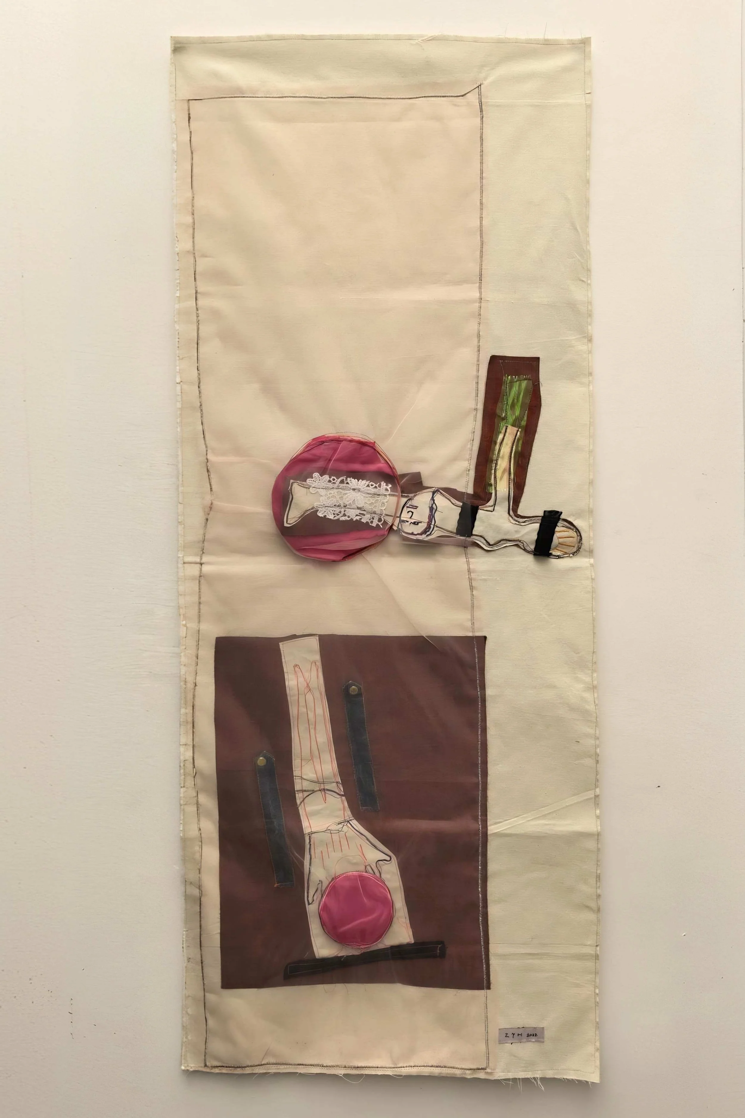 Handcrafted textile wall art combining fabric collage and symbolic stitched elements at EAST WEST SPACE