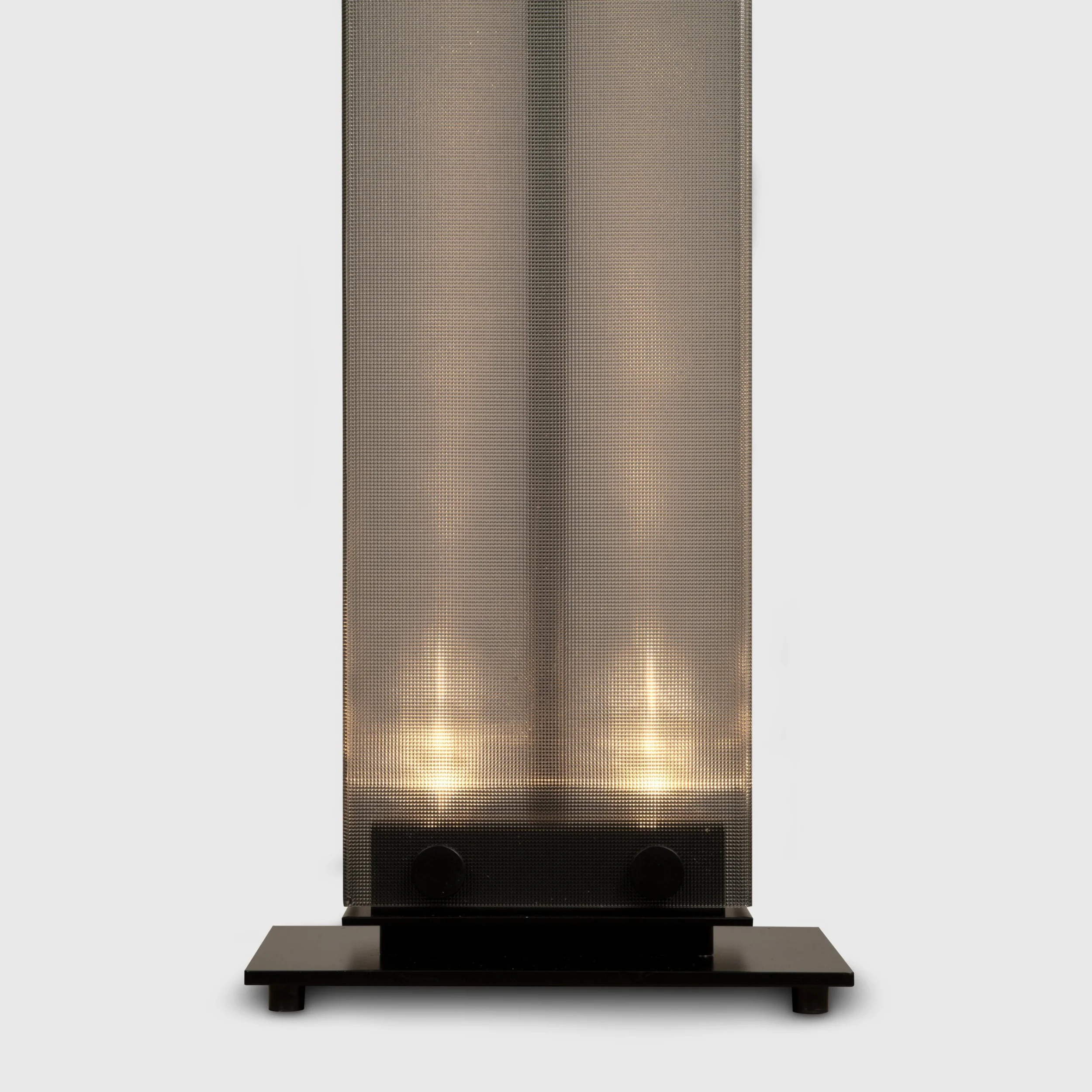 Base of the Belux Twilight floor lamp in black, lit from below with warm LED light