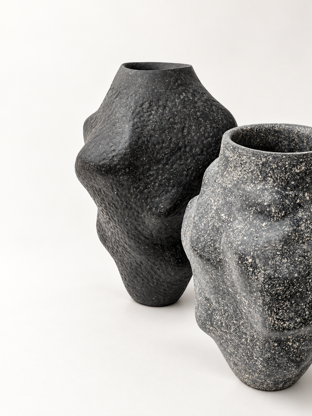 Matte black and speckled charcoal recycled paper vases sculpted by Justino Del Casar