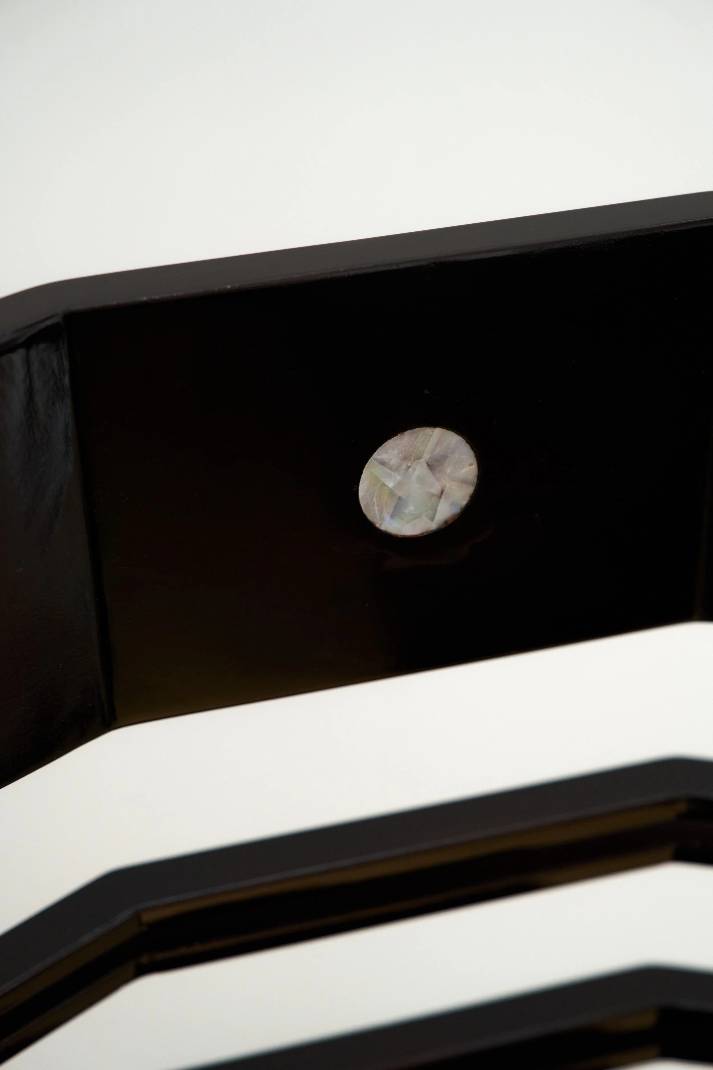 Elegant black chair combining heritage craftsmanship and contemporary materiality.