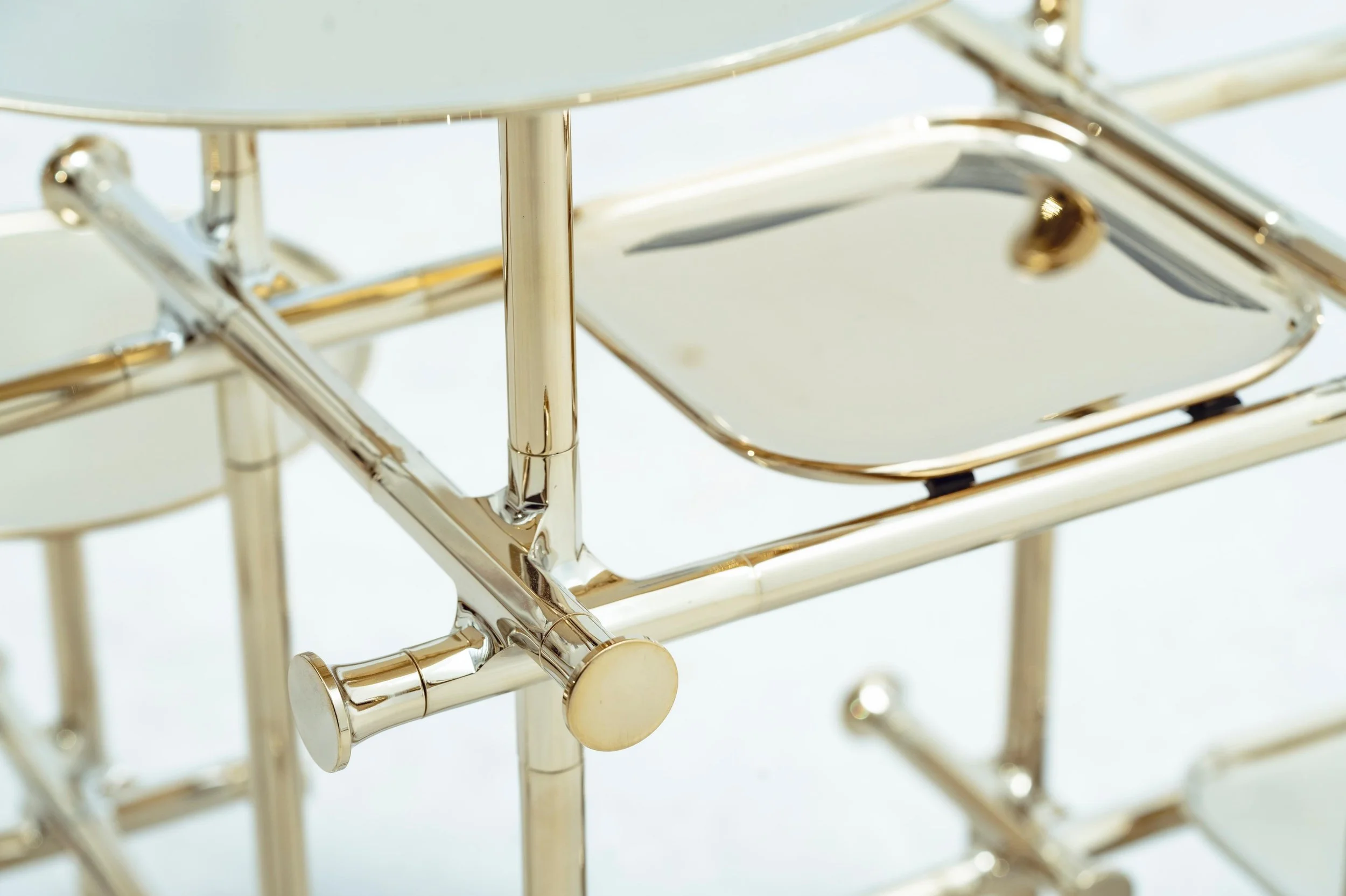 Contemporary brass table-sculpture featuring multi-level circular trays and architectural structure.