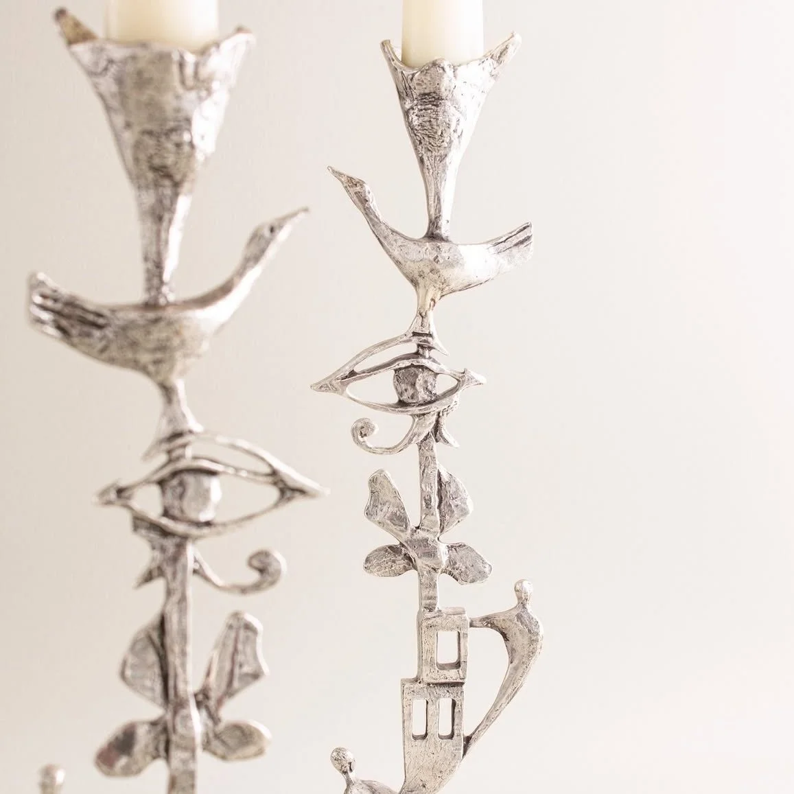 Unique decorative candle holders featuring symbolic bird and eye designs